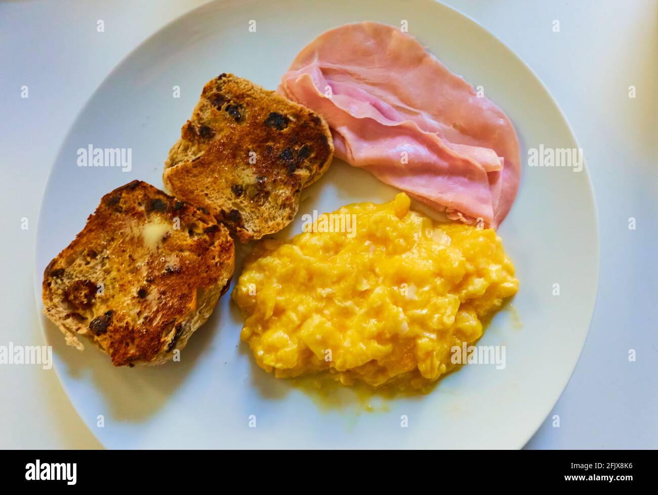 Rührei mit Schinken und geröstetem englischen Teetake Stockfoto