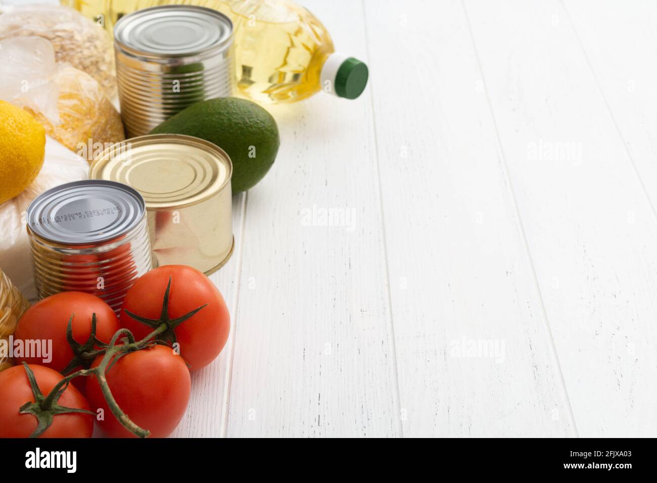 Verschiedene Lebensmittel auf weißem Holztisch. Lebensmittelspende Stockfoto