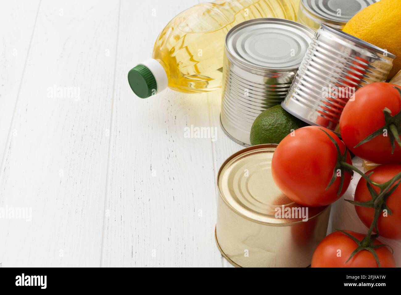 Verschiedene Lebensmittel auf weißem Holztisch. Lebensmittelspende Stockfoto