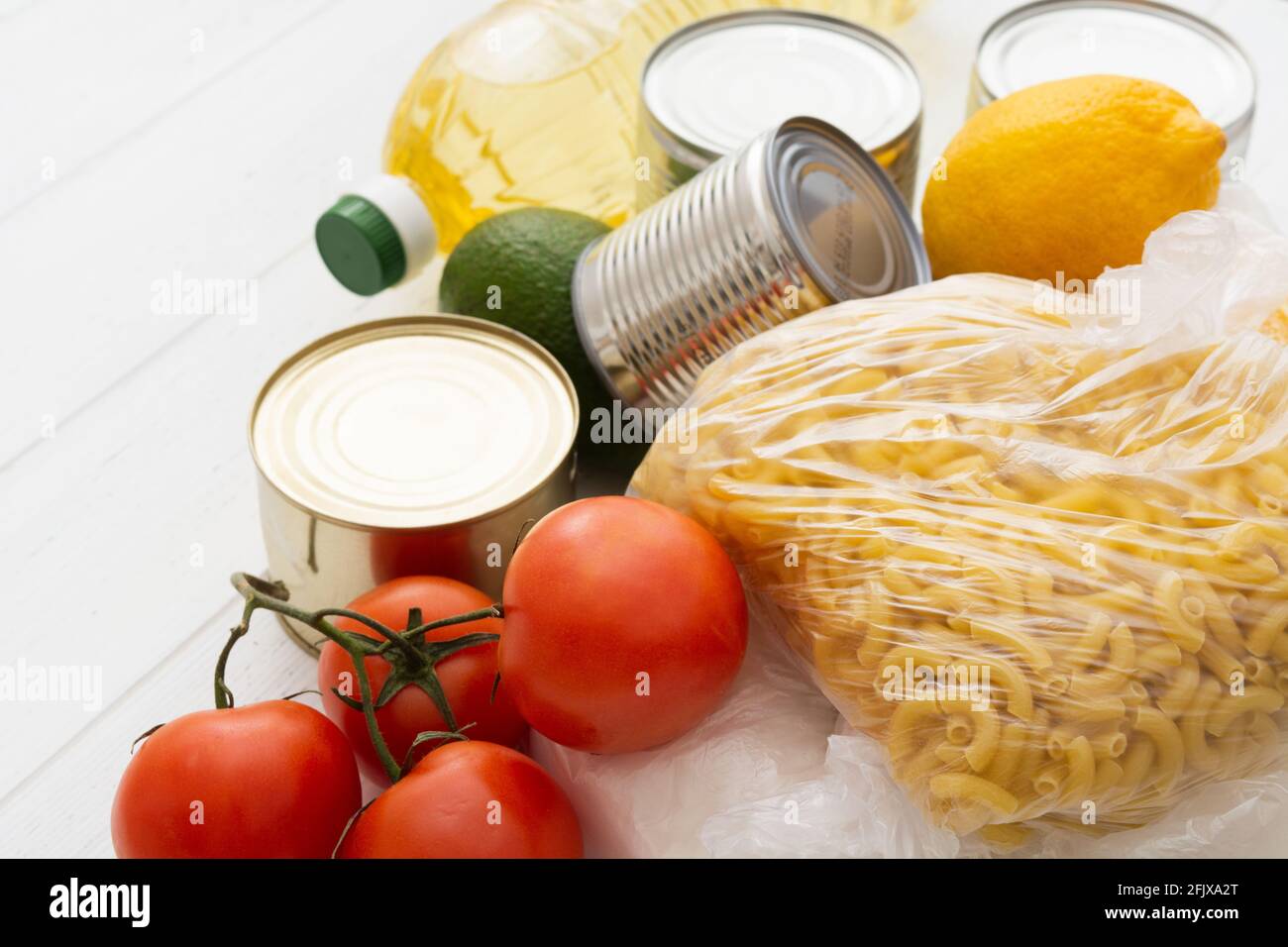 Verschiedene Lebensmittel auf weißem Holztisch. Lebensmittelspende Stockfoto