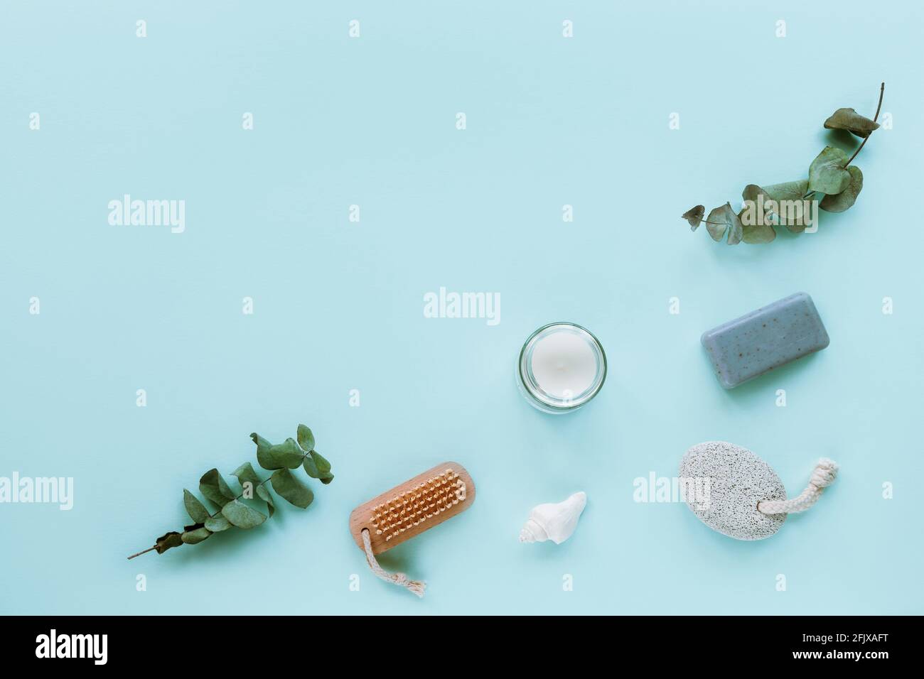Natürliche Bio-Schönheitspflege und Körperpflegeprodukte. Gesichtsbürste, Seife, Bimsstein, Muschel und Kerze. Blauer Hintergrund, Draufsicht, flach Stockfoto