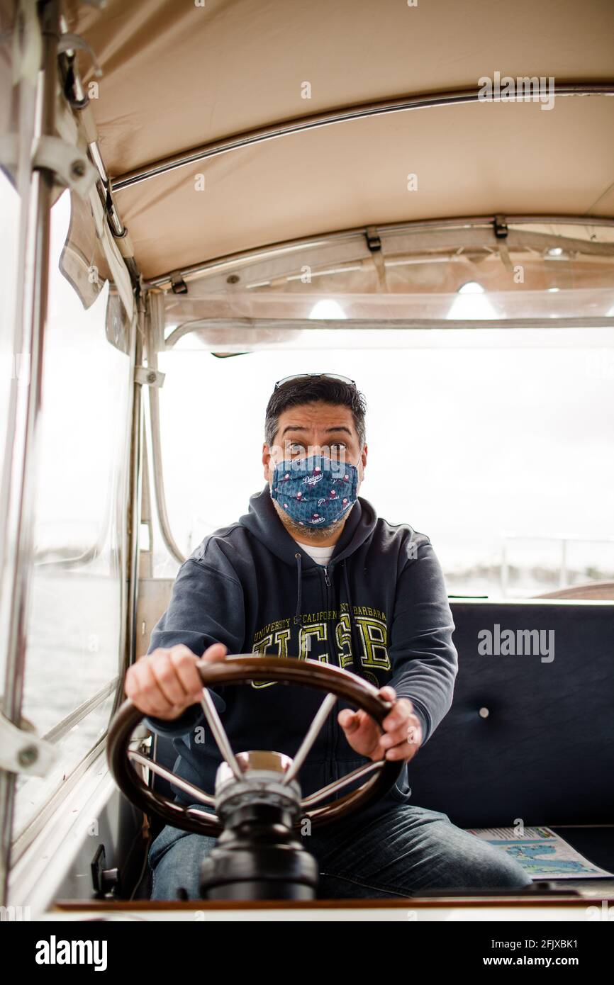 Hispanischer Mann mittleren Alters fährt mit dem Boot auf der Bucht in San Diego Stockfoto