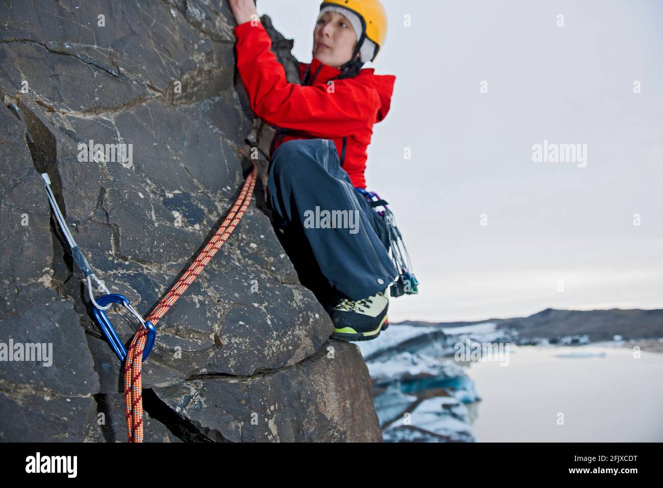 Weibliche Kletterin bestiegt die Felswand in Skaftafell / Island Stockfoto