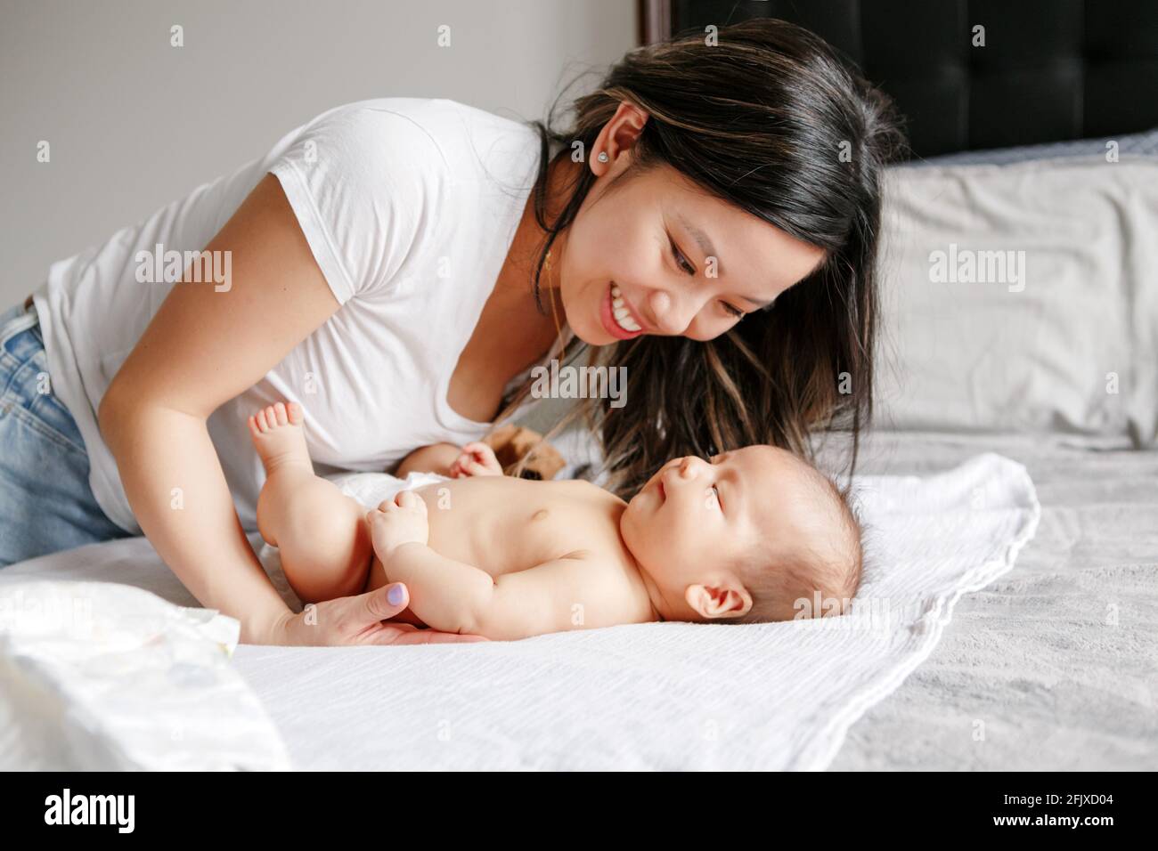 Muttertagsurlaub. Glückliche chinesische asiatische Mutter beim Blick auf neugeborenen Sohn Stockfoto
