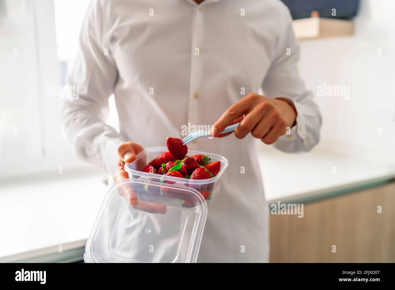 executive schlürft gesunde Früchte in seiner Tupperware Stockfoto