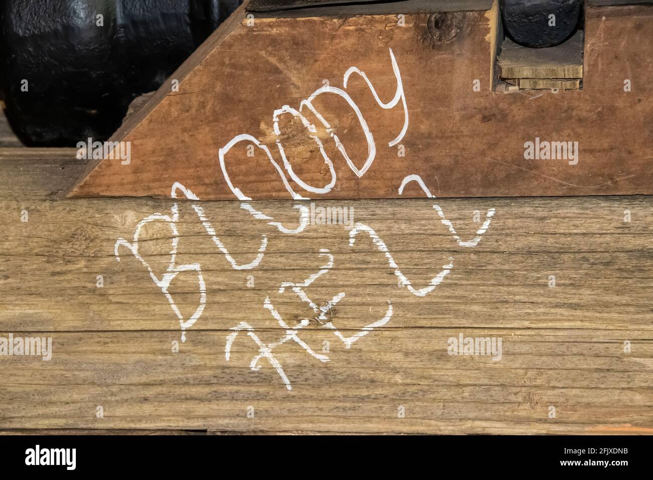 Bloody Hell Handgeschrieben auf Holzteil von Schiffen Kanonen Nahaufnahme Stockfoto