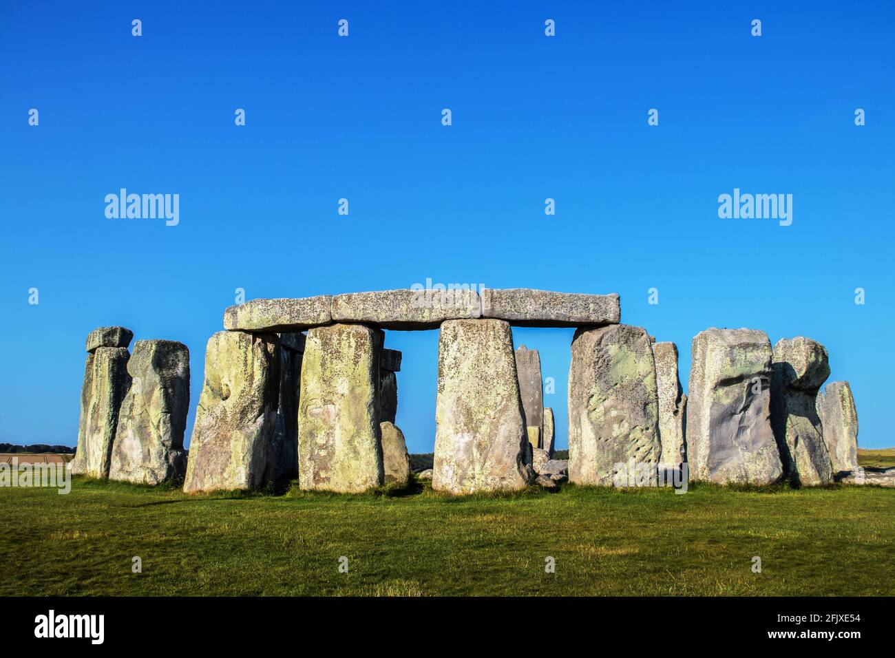 Nahaufnahme von Stonehenge stehenden Steinen mit drei Türmen über vier Riesige Ständer im Vordergrund unter einem sehr blauen Himmel An einem Sommertag mit einer Kasse Stockfoto