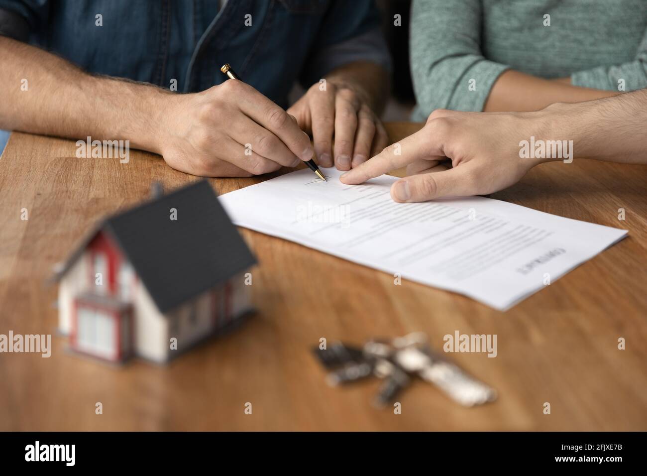 Nahaufnahme des Paares unterzeichnen Deal bei Relator Office Stockfoto