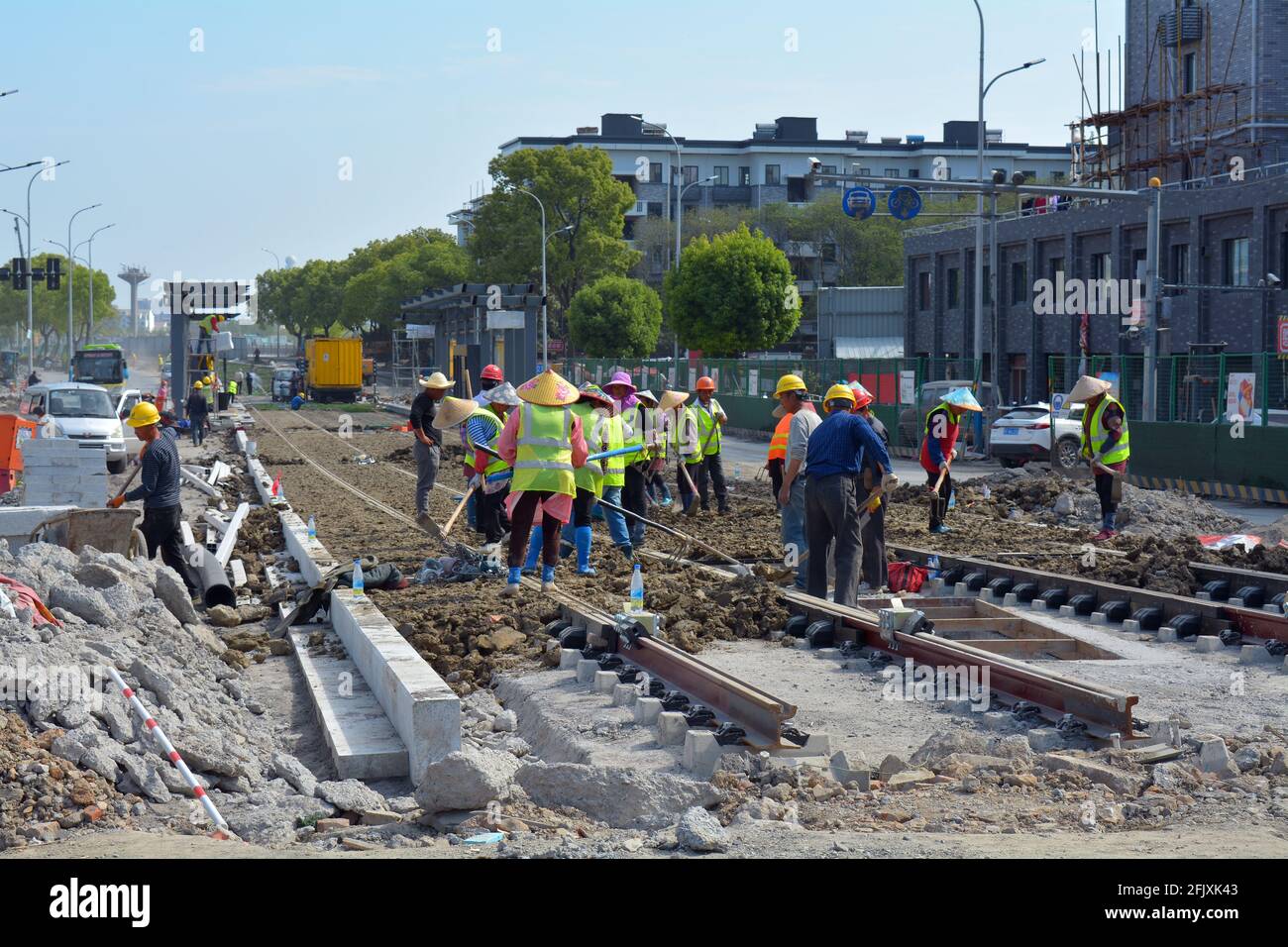 Chinesische Arbeiter, die in Jiaxing eine neue Bahntransitlinie bauen, möglicherweise Wanderarbeitnehmer, einschließlich Frauen, die die Arbeit verrichten. Stockfoto
