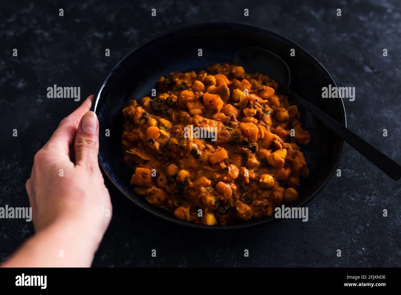 Vegane Kichererbsen und Kürbis-Kürbis-Kürbis-Papykardie mit gewürfeltem Tomatenspinat und Kokosmilch, gesunde pflanzliche Speiserezepte Stockfoto