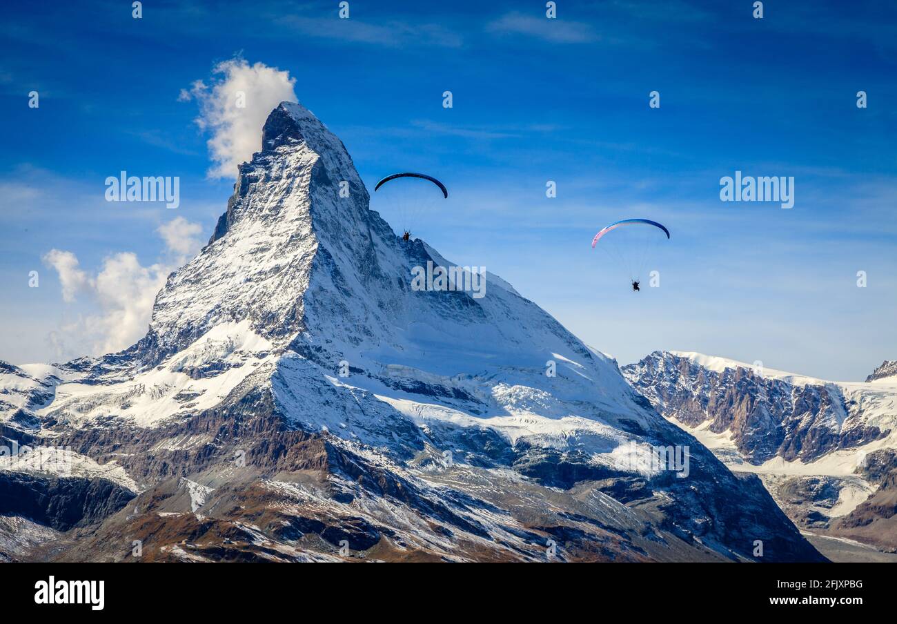 Zwei Gleitschirme über den Schweizer Alpen mit Matterhorn im Hintergrund Stockfoto