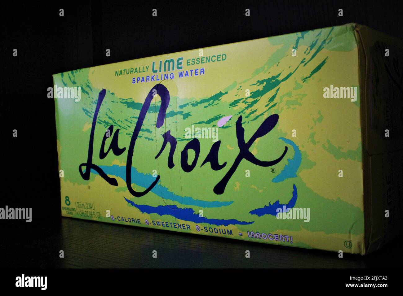 Schachtel mit Lacroix, Natral Lime Essensed, glitzerndem Wasser auf schwarzem Hintergrund Stockfoto