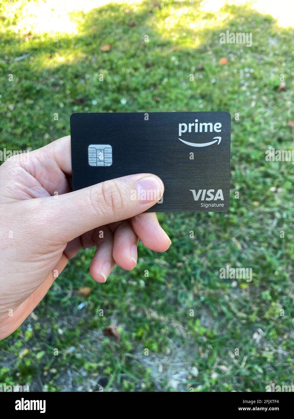 Eine Frau hält eine Amazon Prime Rewards Visa Signature Card in der Hand. Stockfoto