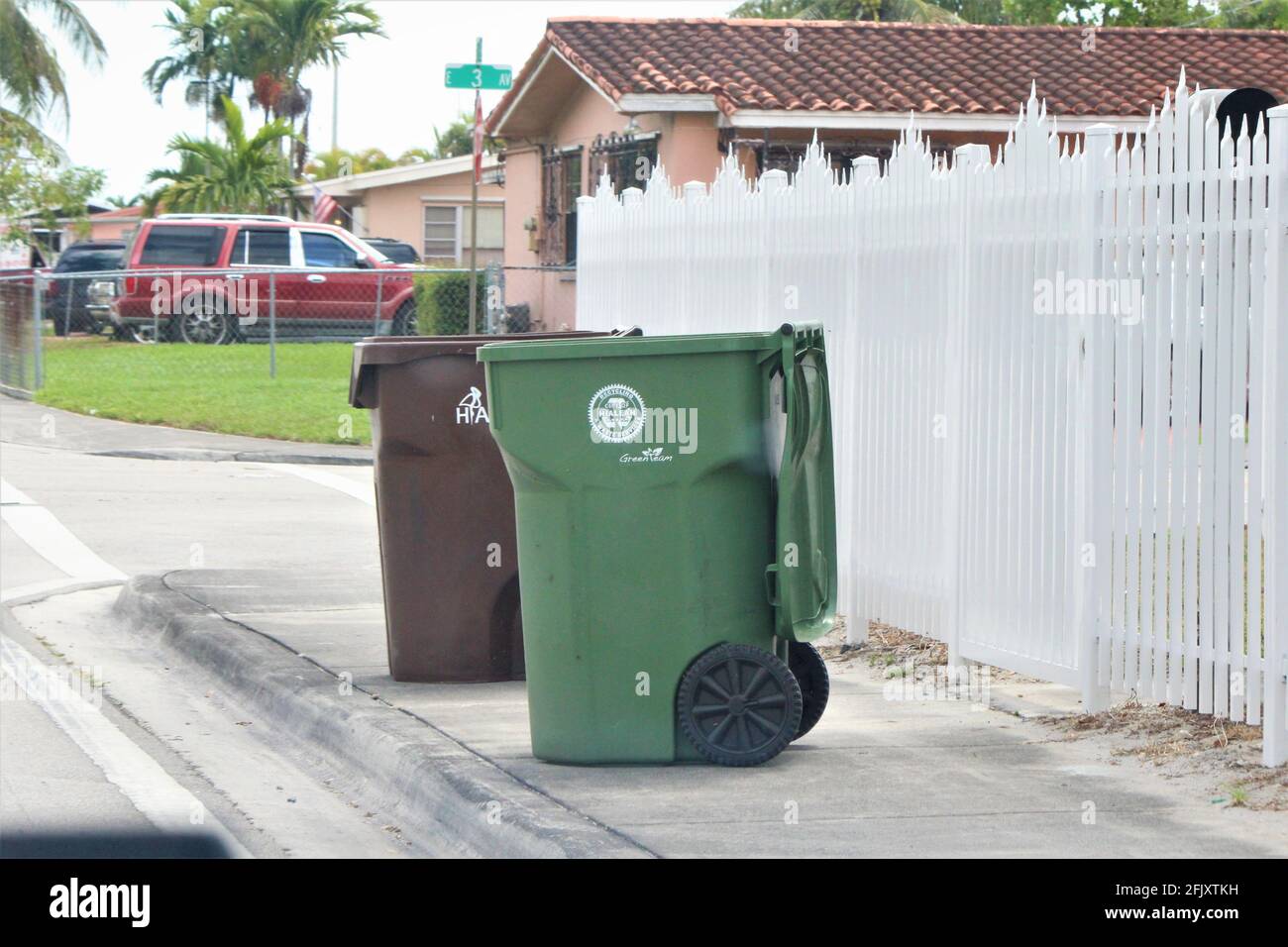 Recycling- und Mülltonnen aus der Stadt Hialeah On Ein Bürgersteig vor einem Wohnhaus Stockfoto
