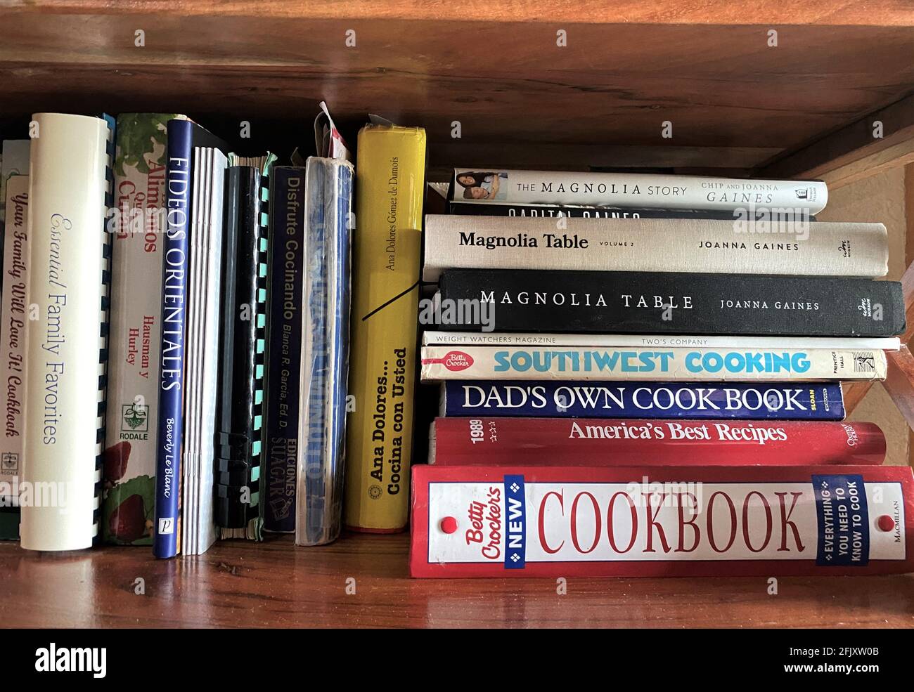 Kochbücher für die Küche wurden im Regal zusammengebündelt. Es werden viele verschiedene Küchen gezeigt. Stockfoto
