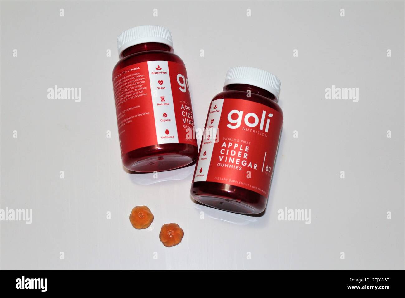 Flaschen mit Goli Apfelessiggummis, die die tatsächlichen rosa gummies zeigen. Tägliche Zuschläge. Weißer isolierter Hintergrund. Glutenfrei, nicht gentechnisch verändert Stockfoto