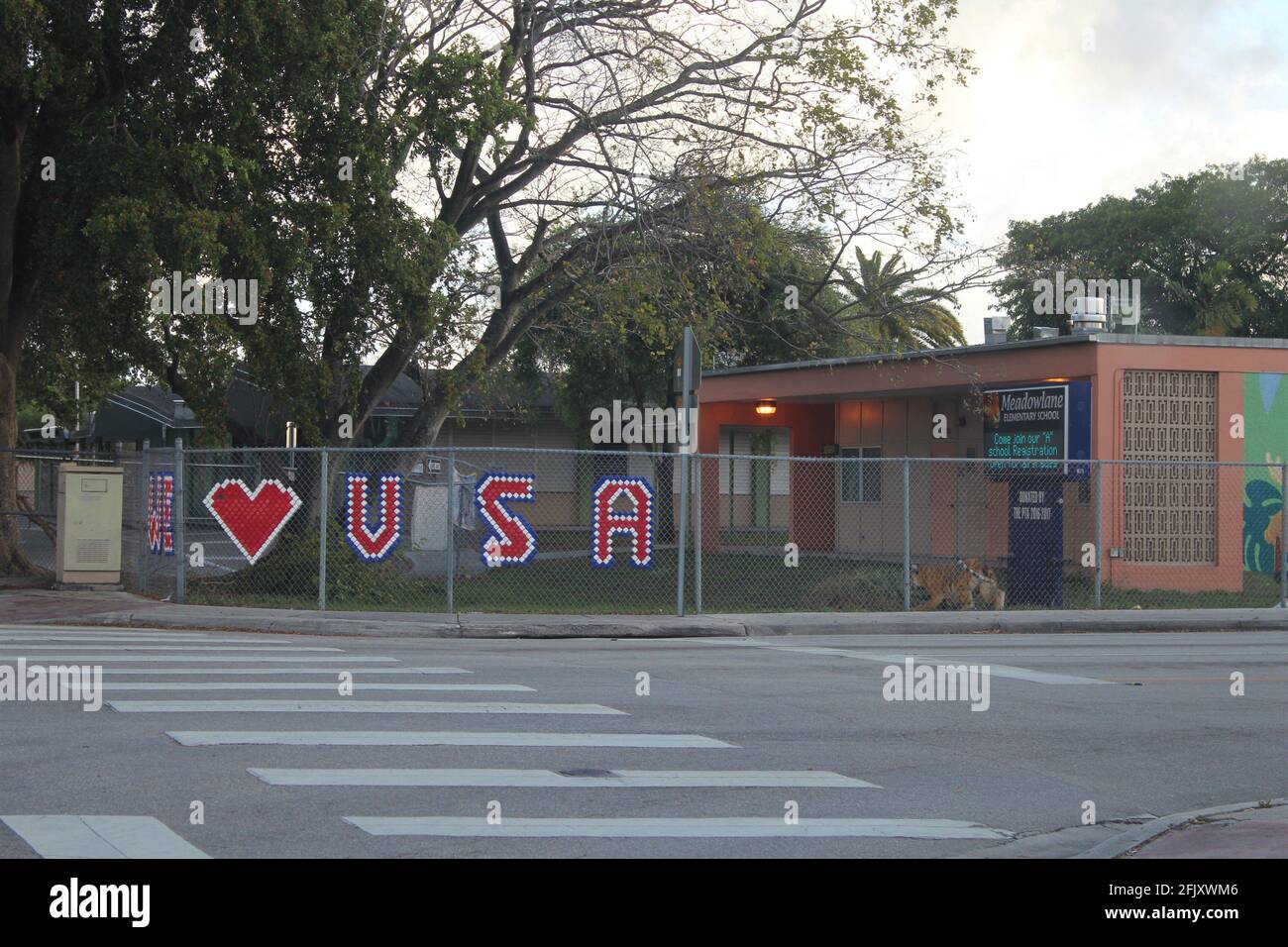 Die Meadowlane Elementary School in Hialeah, Florida, zeigt auf einem Zaun ein Schild „Wir lieben die USA“ mit Patriotismus. Stockfoto