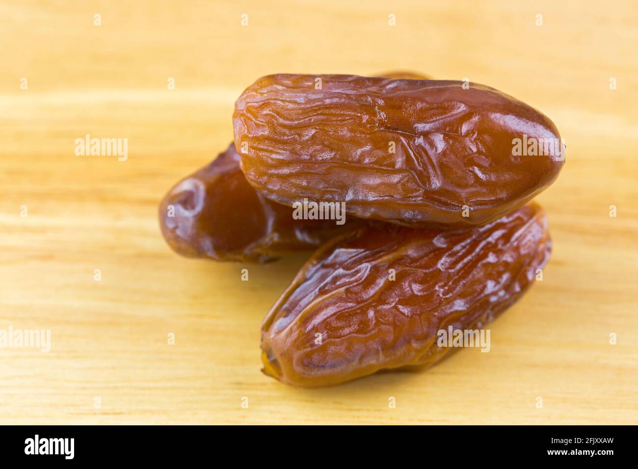 Nahaufnahme von natürlichen getrockneten Datteln Früchte auf Holzhintergrund (Phoenix dactylifera) Stockfoto