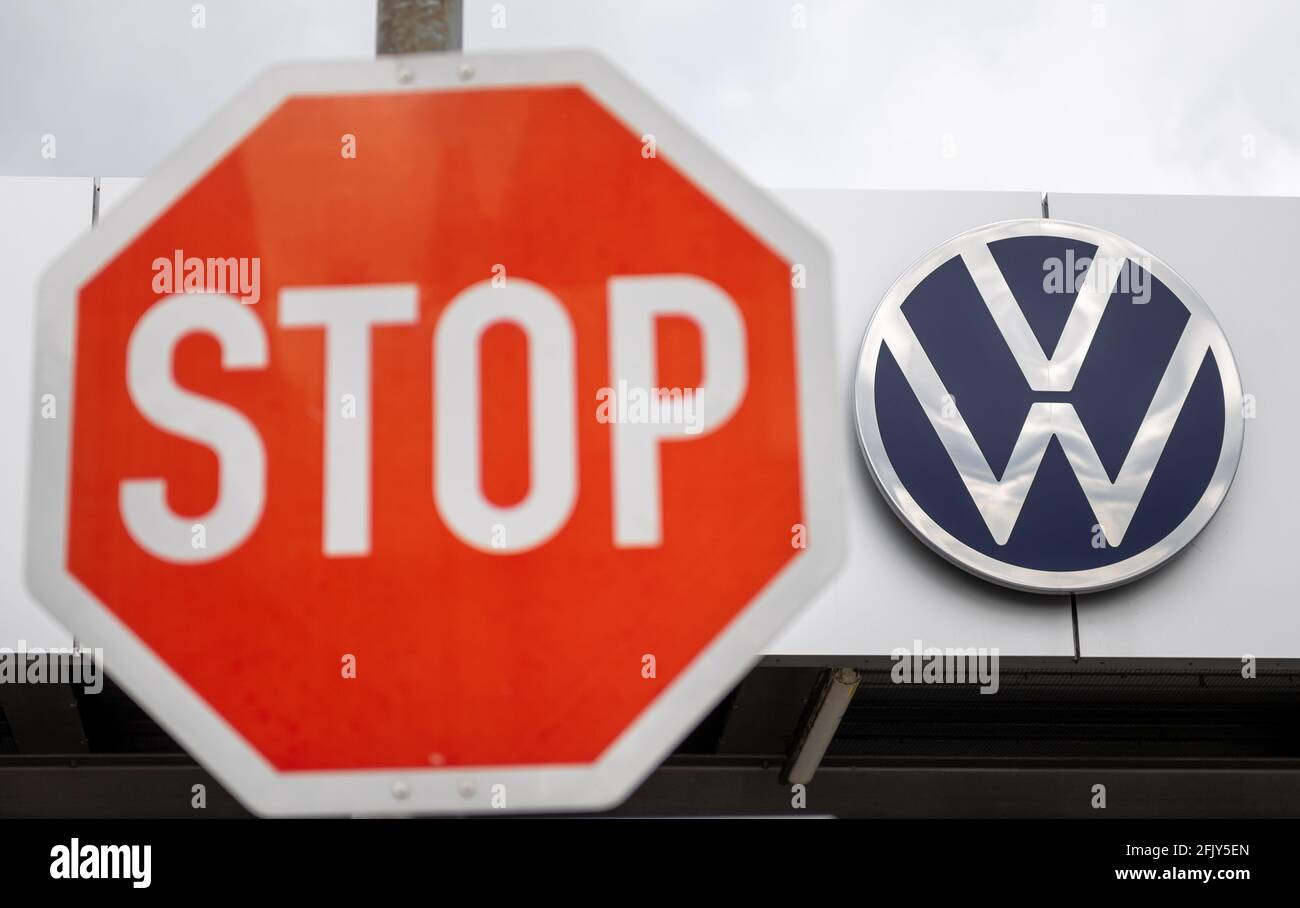Zwickau, Deutschland. April 2021. Ein Stoppschild ist neben dem Volkswagen-Logo am Eingang zum VW-Werk in Zwickau zu sehen. Quelle: Hendrik Schmidt/dpa-Zentralbild/ZB/dpa/Alamy Live News Stockfoto