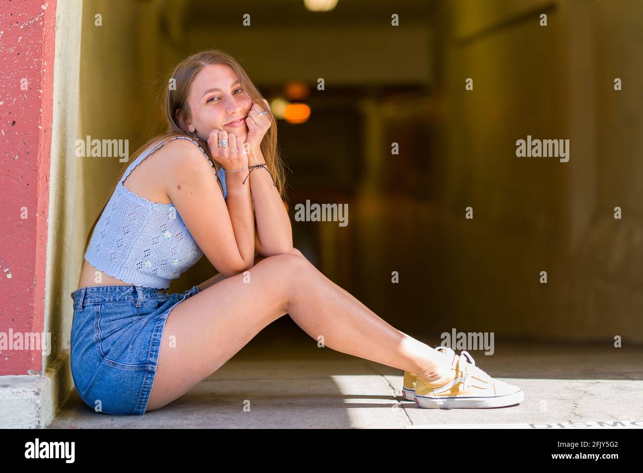 Junge Frau saß auf dem Boden in der Nähe eines Fußgängertunnels Stockfoto