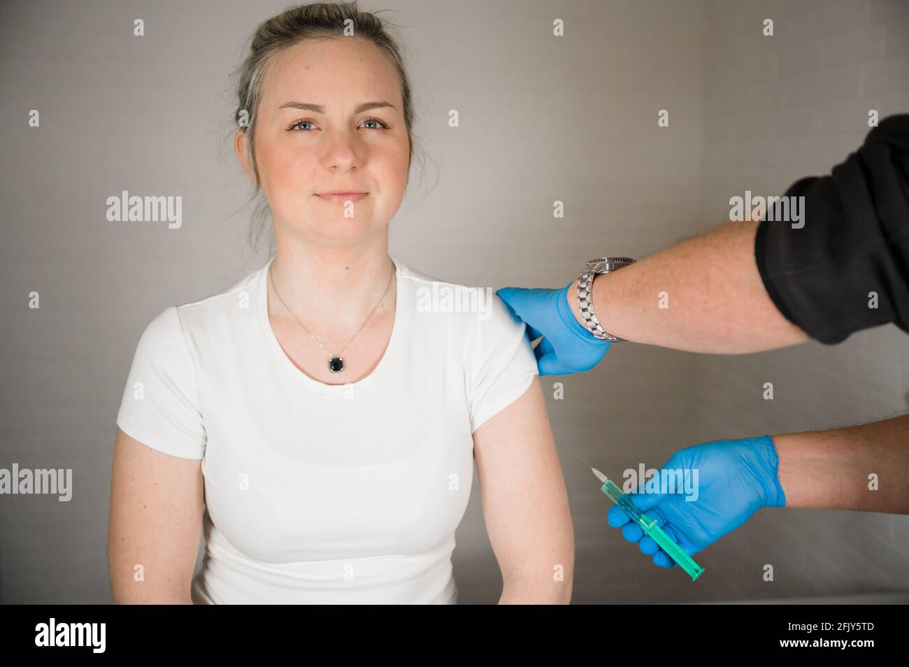 Arzt injiziert Covid-Impfstoff in einen Patientenarm: Heilung der Corona-Pandemie durch Massenimpfung Stockfoto