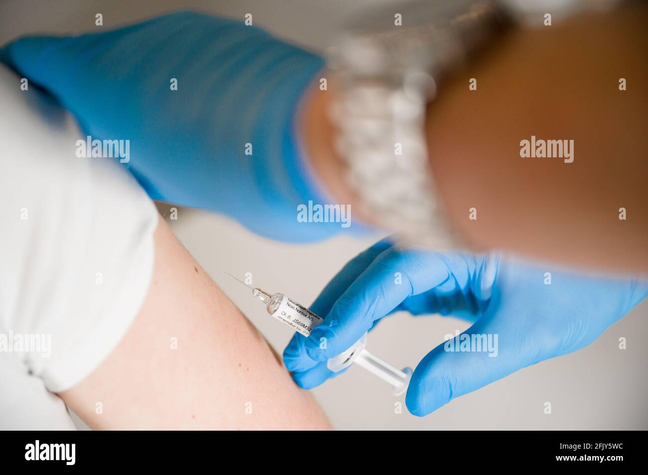 Arzt injiziert Covid-Impfstoff in einen Patientenarm: Heilung der Corona-Pandemie durch Massenimpfung Stockfoto