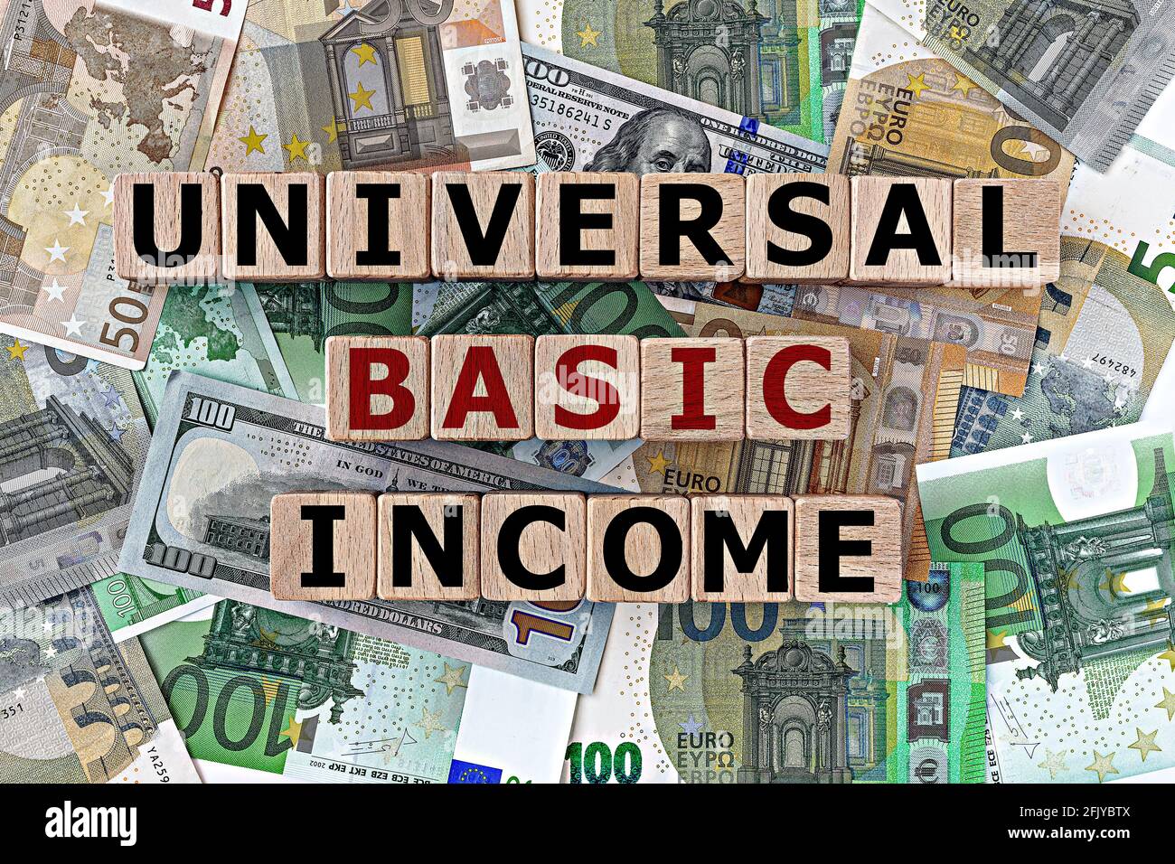 topview Foto zum Thema Grundeinkommen. Holzwürfel mit der Aufschrift 'Grundeinkommen universell', auf dem Hintergrund von Dollar- und Euro-Scheinen Stockfoto