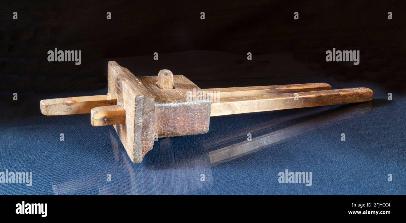 Ein altes Messwerkzeug für einen Zimmermann auf dem Tisch. Holzobjekt auf schwarzem Hintergrund Stockfoto