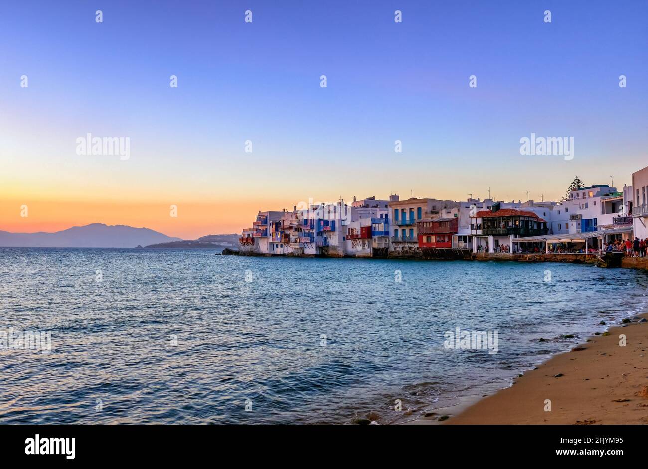 Wunderschöne Sonnenuntergangsansicht von Little Venice, Mykonos, Griechenland. Romantisches Viertel mit Bars, Cafés, Restaurants in alten Fischerhäusern über den Wellen des Meeres Stockfoto