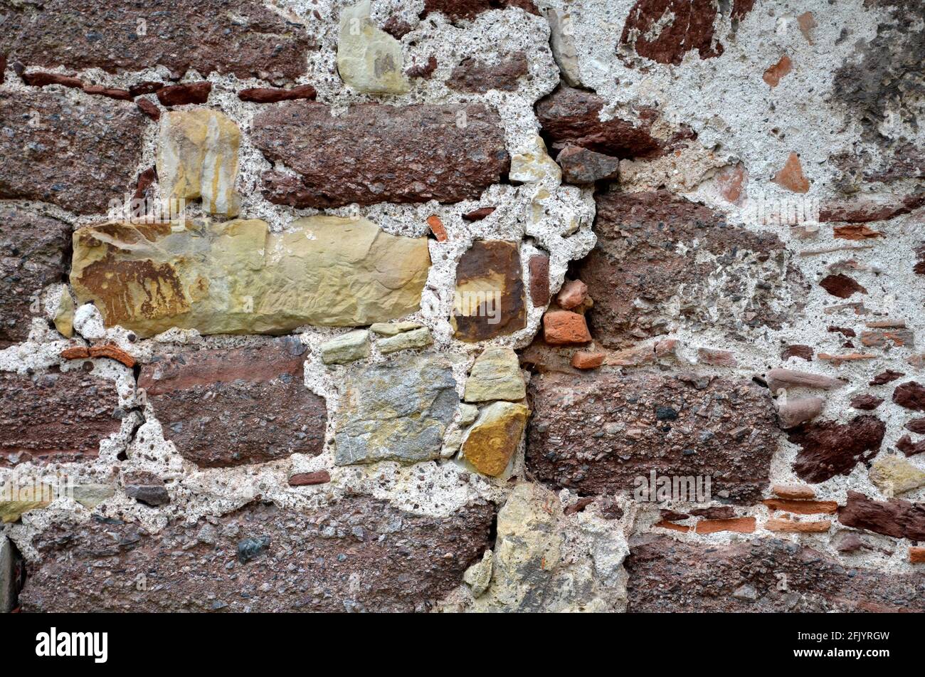 Verschiedenfarbige Steine in einer Wand eines alten Gebäudes Stockfoto