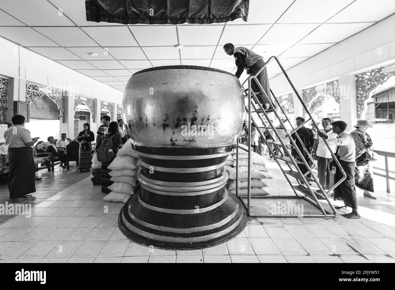 Besucher, die Geld in EINEN großen Container im Manuha Tempel, Bagan, Mandalay Region, Myanmar, investieren. Stockfoto