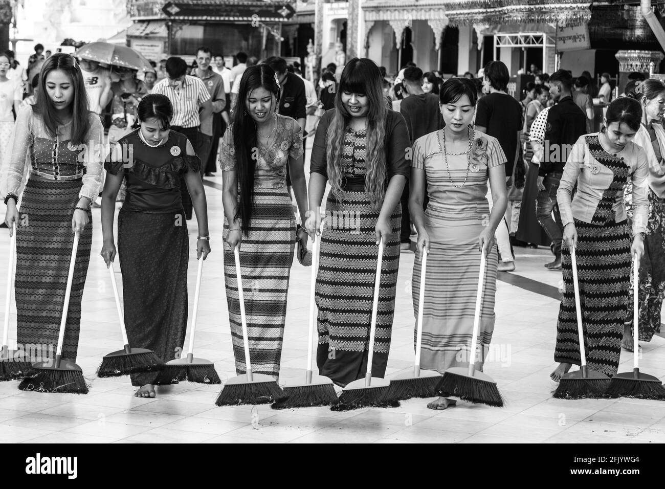 Weibliche Besucher der Shwedagon Pagode nehmen am täglichen Ritual der Reinigung und Säuberung des Geländes, der Shwedagon Pagode, Yangon, Myanmar, Teil. Stockfoto