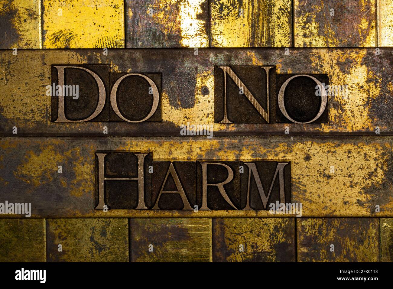 „Do No Harm“-Buchstabenkunst auf vintage strukturiertem Graukupfer Und Gold Steampunk Hintergrund Stockfoto