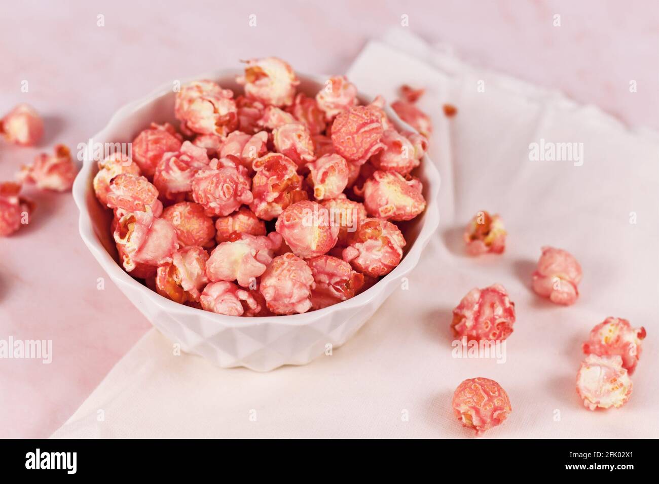 Süßes Popcorn mit rosa Erdbeergeschmack in einer weißen Schüssel Stockfoto