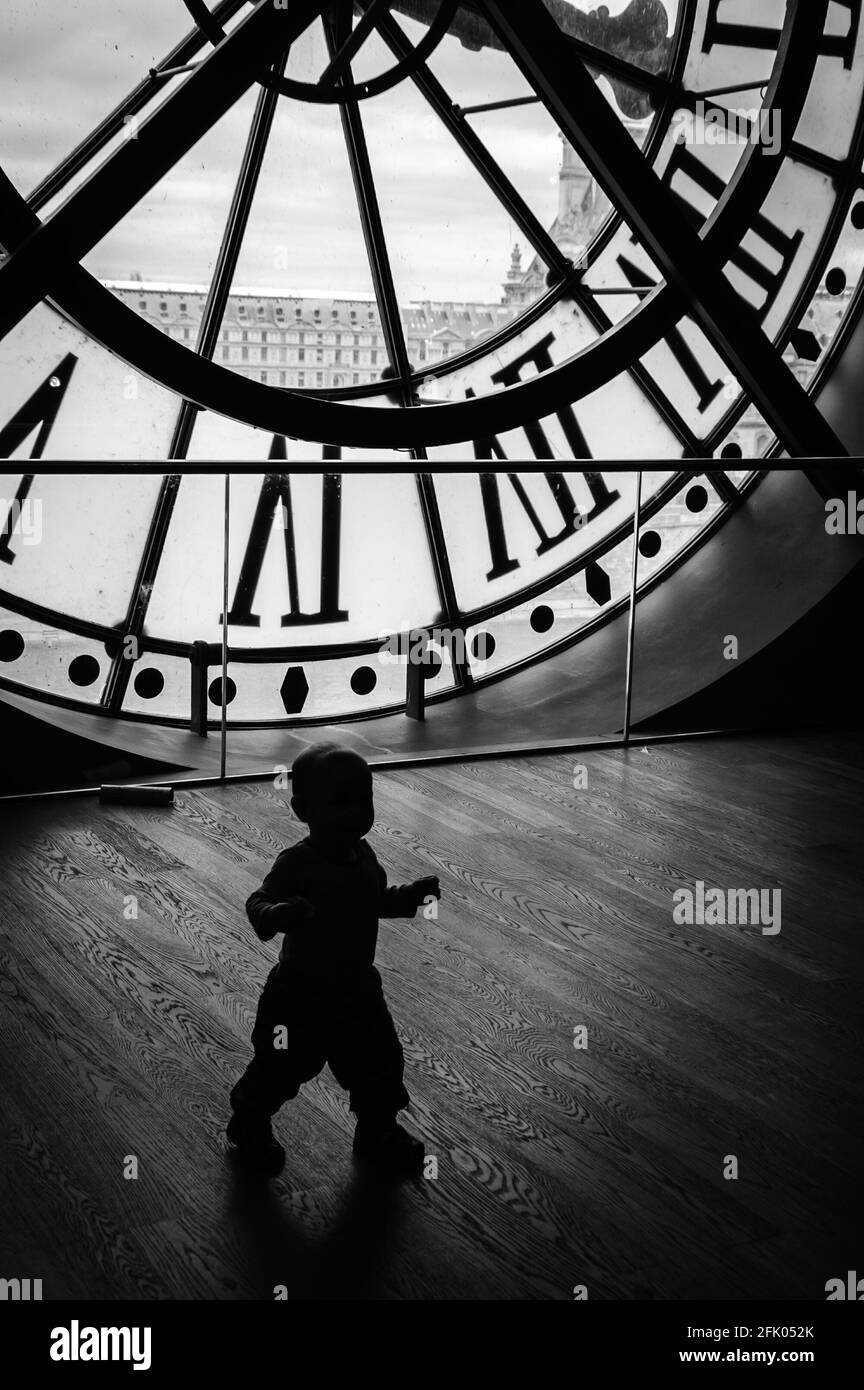 PARIS, FRANKREICH - 6. APRIL 2014: Eine Uhr im Museum D'Orsay und eine Silhouette eines nicht identifizierten kleinen Jungen mit seiner Mutter, die das Konzept o illustriert Stockfoto