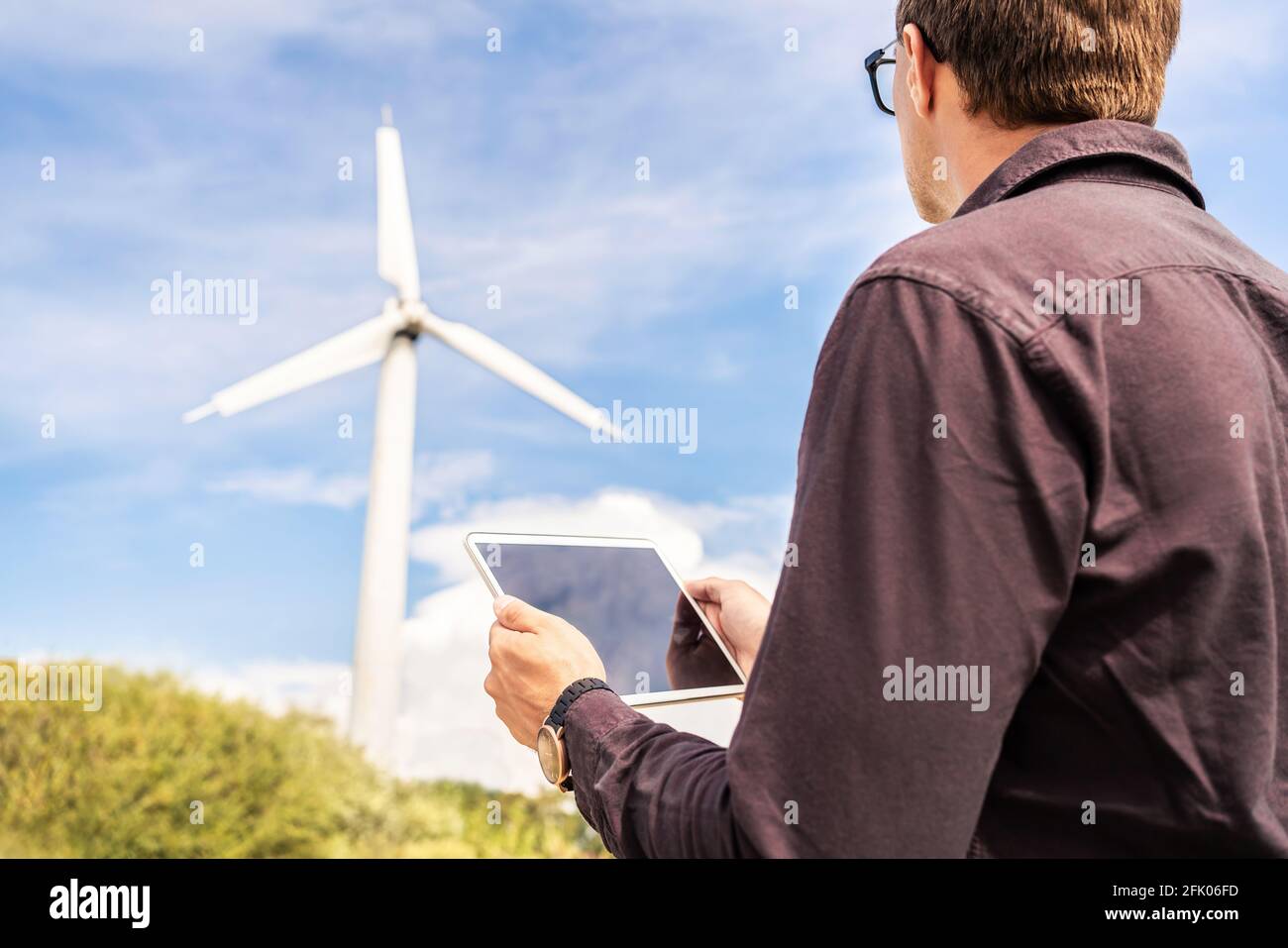 Ingenieur und Tablet im Windpark, der für erneuerbare, nachhaltige Energie arbeitet. Techniker in der industriellen Stromerzeugung. Stockfoto