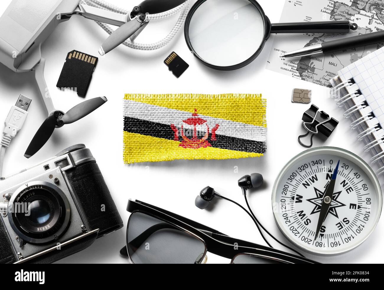 Flagge von Brunei und Reisezubehör auf weißem Hintergrund. Stockfoto