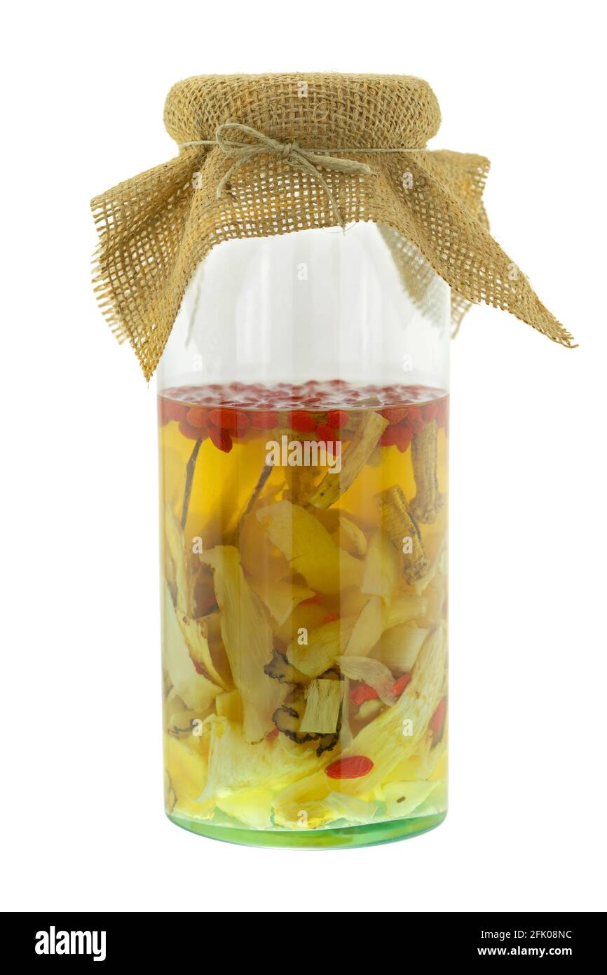 Hausgemachte chinesische medizinische Spirituosen in Glas. Infundierter Alkohol mit chinesischen Kräutern, isoliert auf weißem Hintergrund - Lakritz, Radix Ginseng, Goji-Beere, Stockfoto