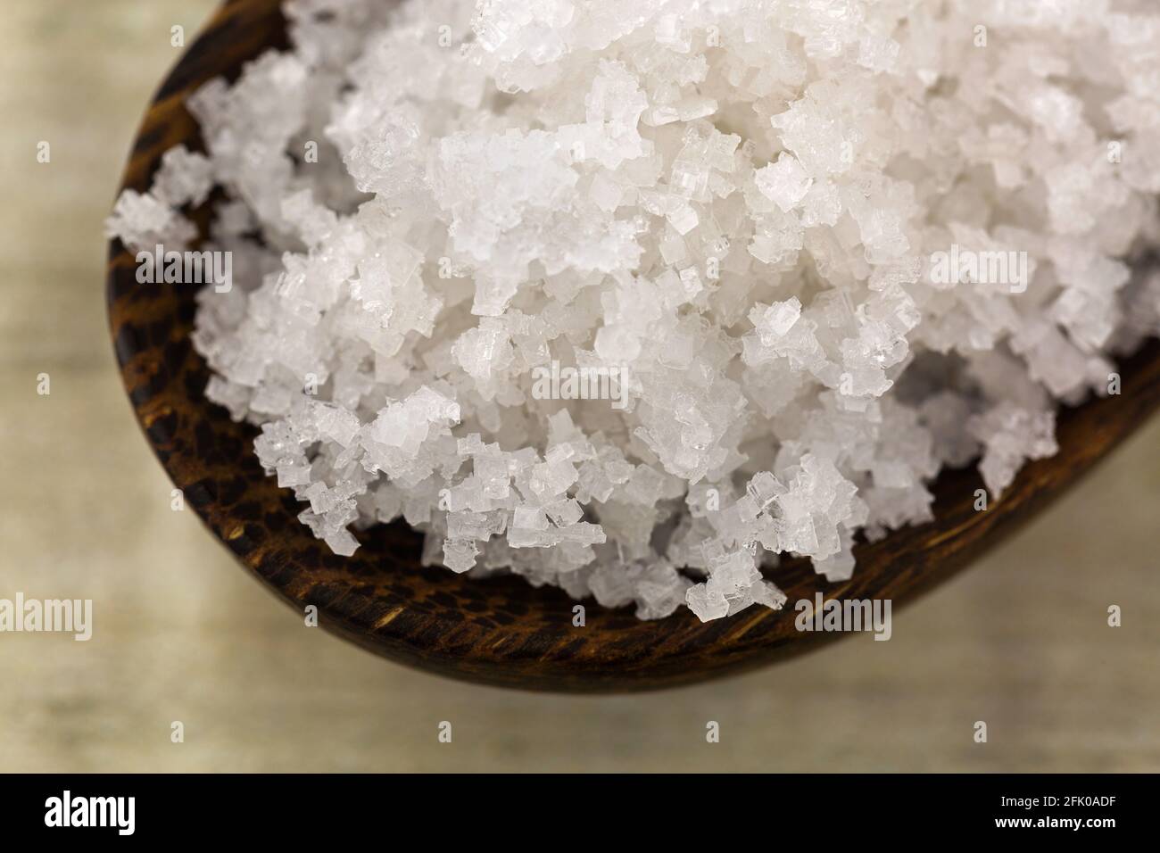 Nahaufnahme Blume des Salzes, gesammelt aus der dünnen Schicht auf der Meerwasseroberfläche, im Holzlöffel. Auf Französisch Fleur de sel genannt. Stockfoto