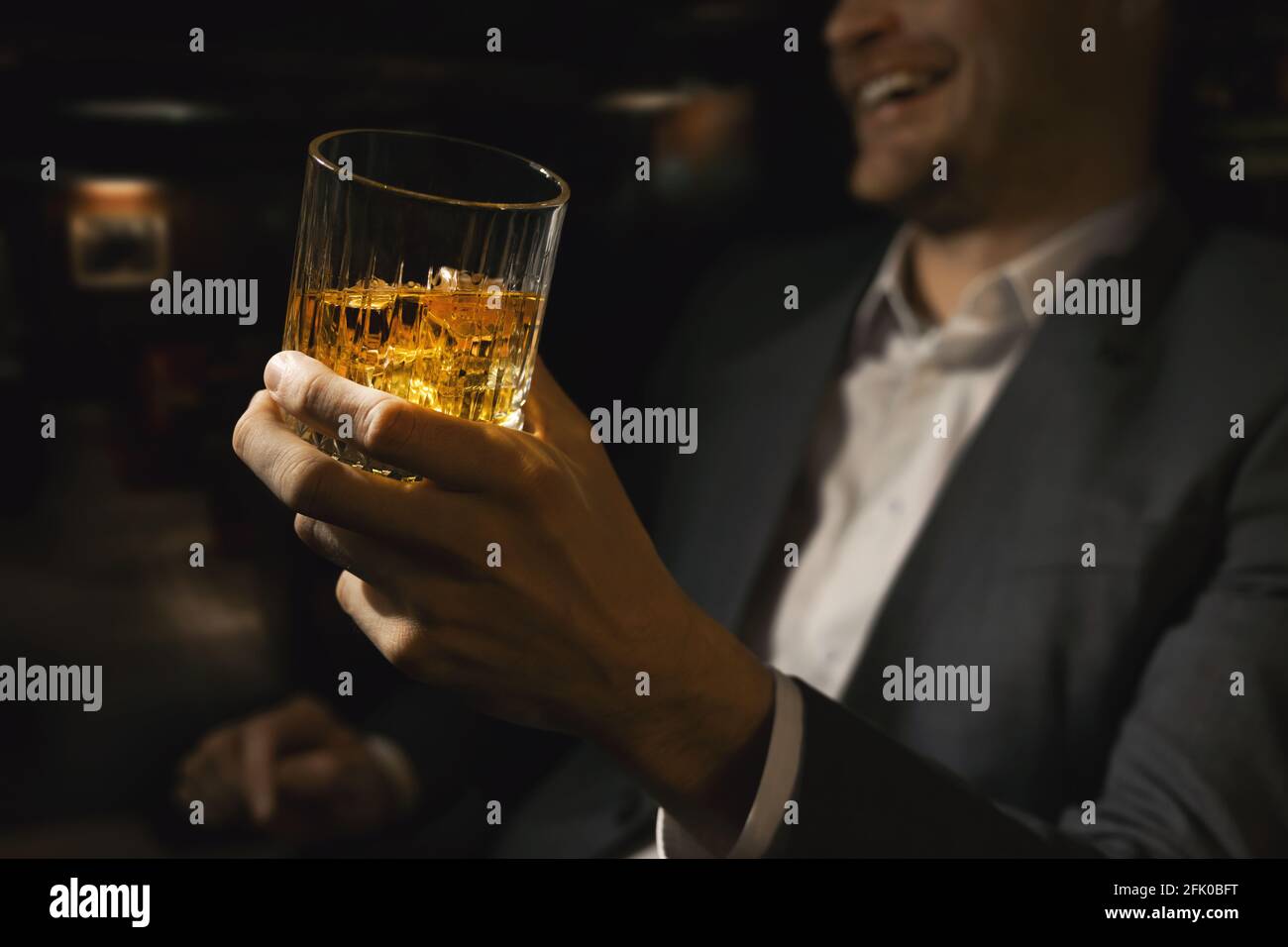 Glücklicher Geschäftsmann mit einem Glas Whiskey in der Gentlemen Club Bar Stockfoto