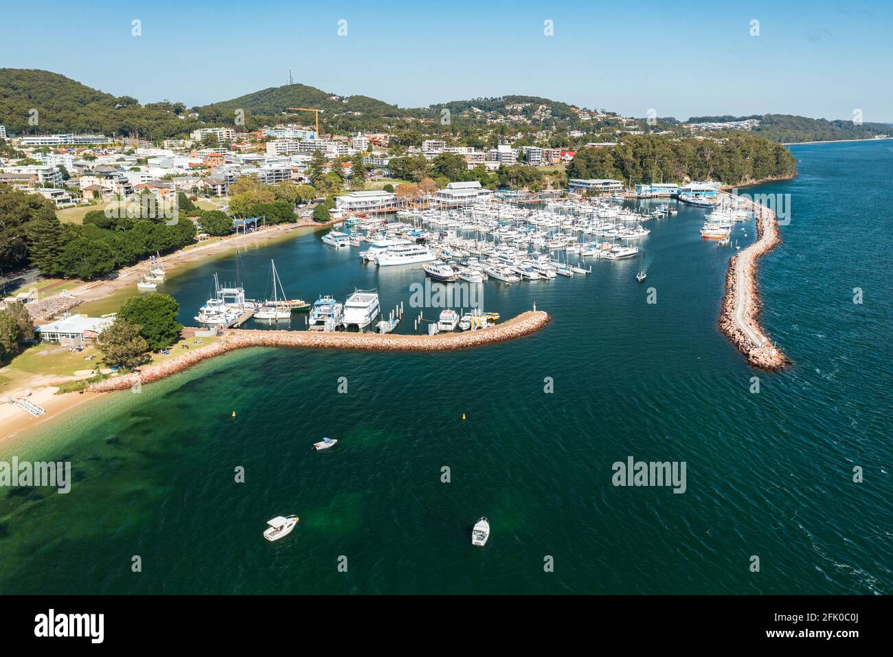 Luftaufnahme des Yachthafens von Nelson Bay, des Wellenbrechers und der Stadt, mit dem Wasser von Port Stephens, Australien. Stockfoto
