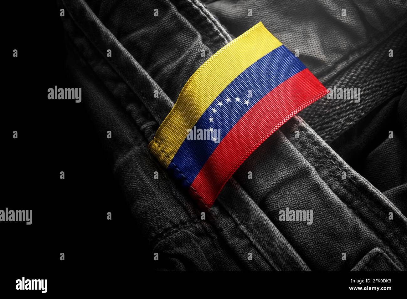 Anhänger auf dunkler Kleidung in Form der Flagge Venezuela Stockfoto