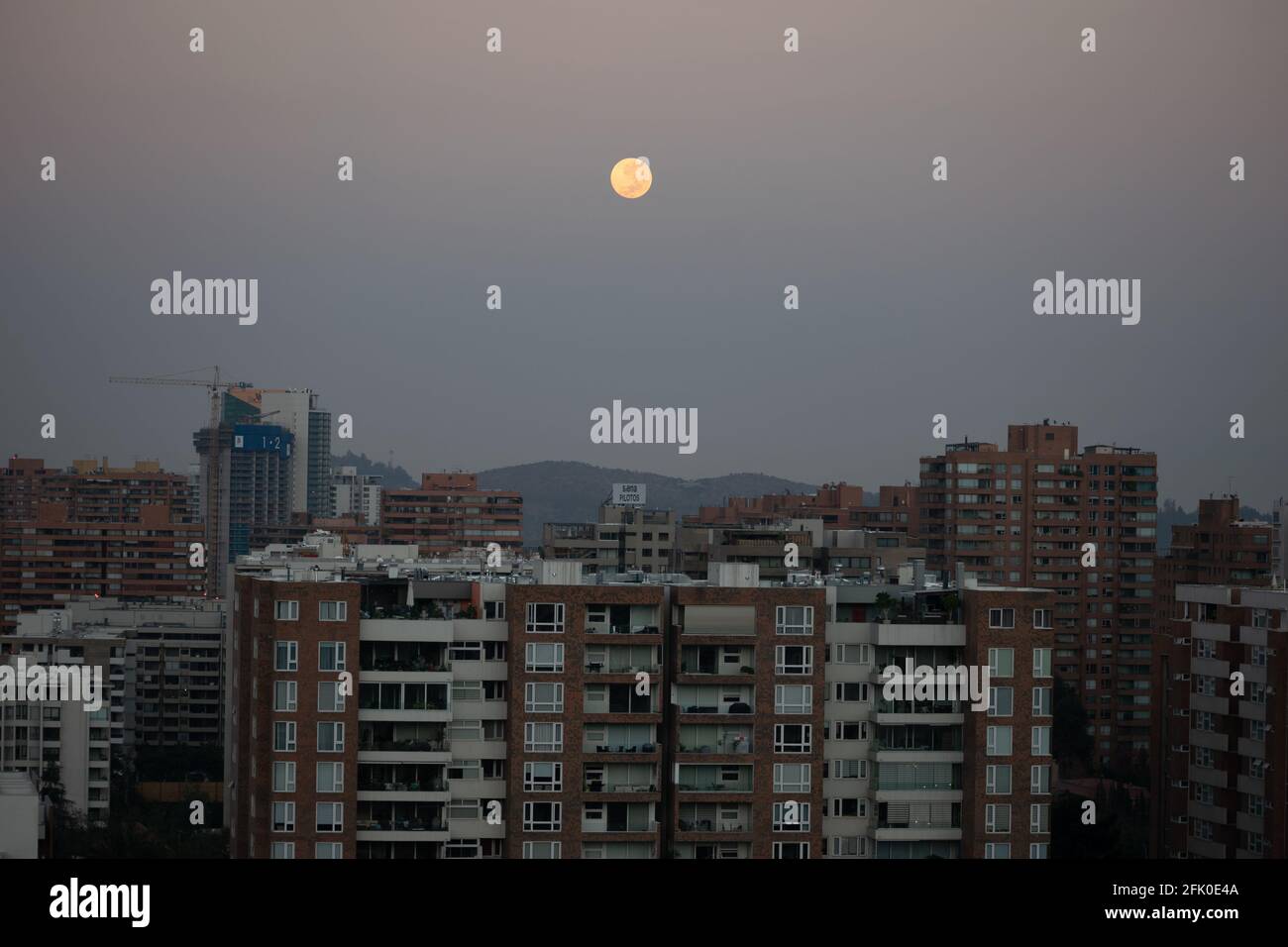 27. April 2021, Santiago, Metropolitana, Chile: Der rosafarbene Supermond versteckt sich bei Sonnenaufgang in Santiago, Chile, hinter Gebäuden. (Bild: © Matias Basualdo/ZUMA Wire) Stockfoto