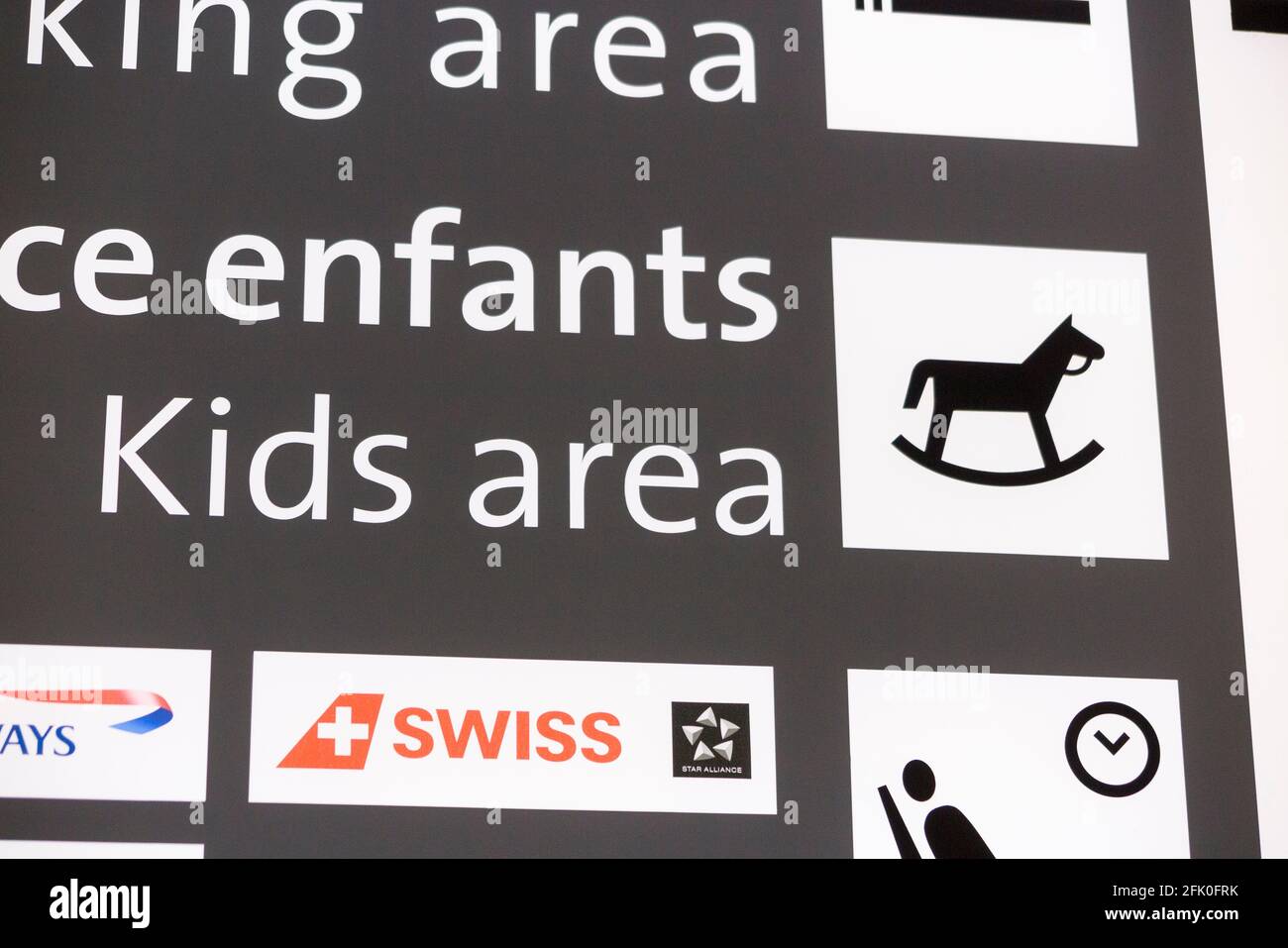 Schild/Bildschirm, auf dem die Position der Kinder/der Kinderspielplatz in der Abflughalle des Flughafens Genf/Genf, Cointrin, Schweiz, angegeben ist. (101) Stockfoto