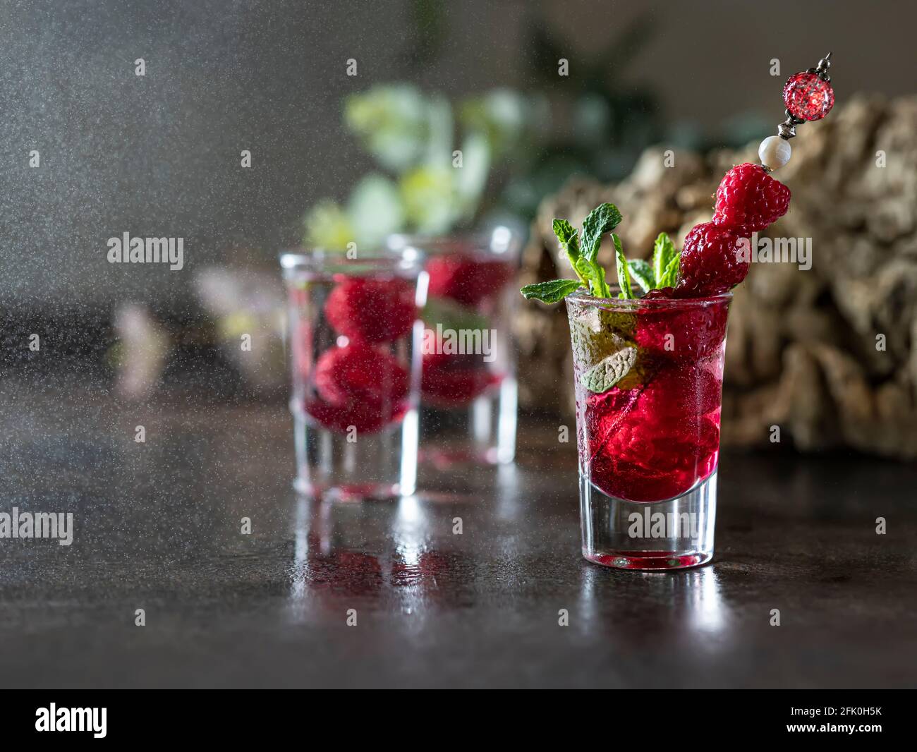 Himbeer-Wodka-Glas mit Obst innen geschossen. Frische Sommeraufnahmen für  Partys. Beeren in Alkoholglas. Ein Glas Mineralwasser. Alkoholeinschläge  Stockfotografie - Alamy