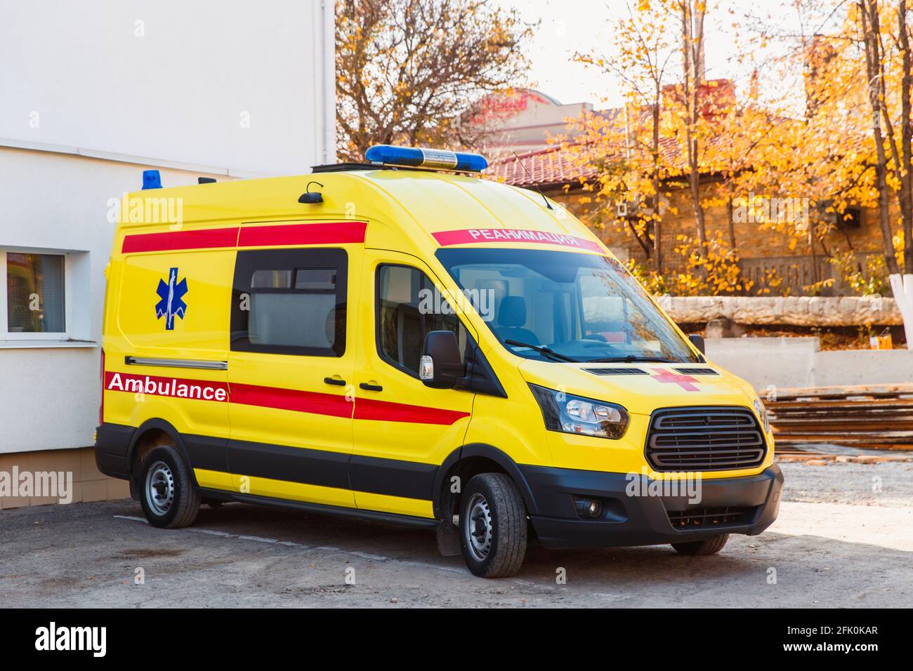 Zaporozhye, Ukraine- November 08 2019 :Gelber Krankenwagen steht in der Nähe des Krankenhausgebäudes. Seitenansicht. Stockfoto