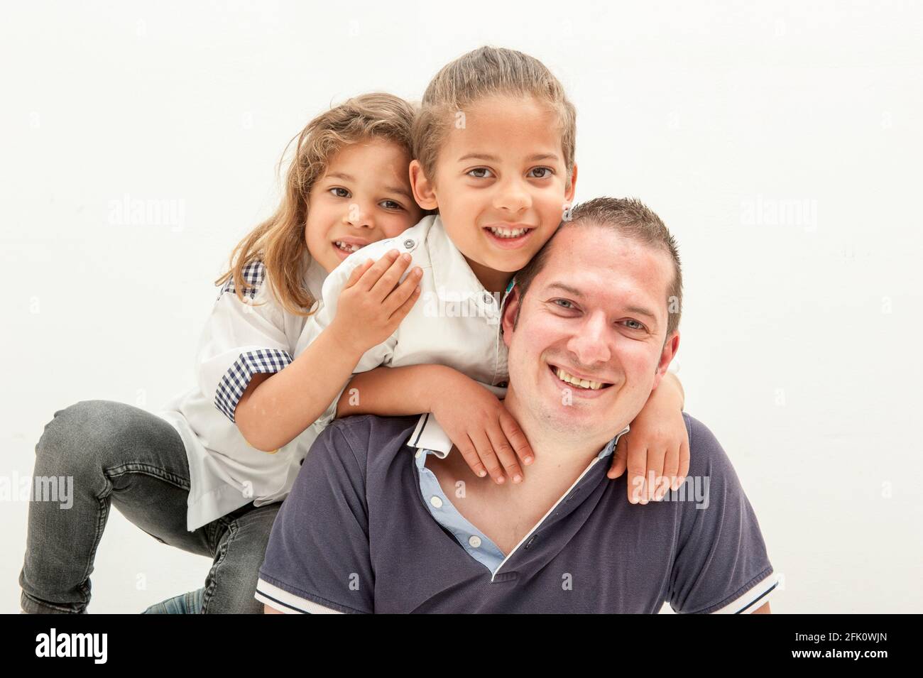 Glücklicher junger kaukasischer Vater, der Spaß mit kleinen multirassischen Kindern hat glücklicher Vater spielt in lustigen Aktivitäten mit kleinen multiethnischen Kindern. Stockfoto