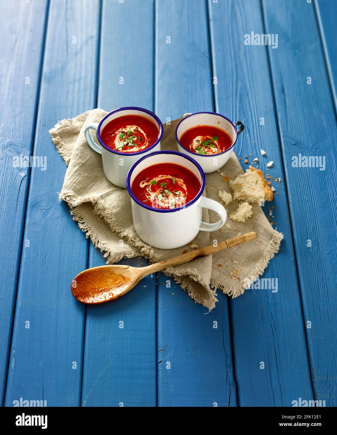 Rustikale Tomatensuppe auf blauem Tischhintergrund Stockfoto