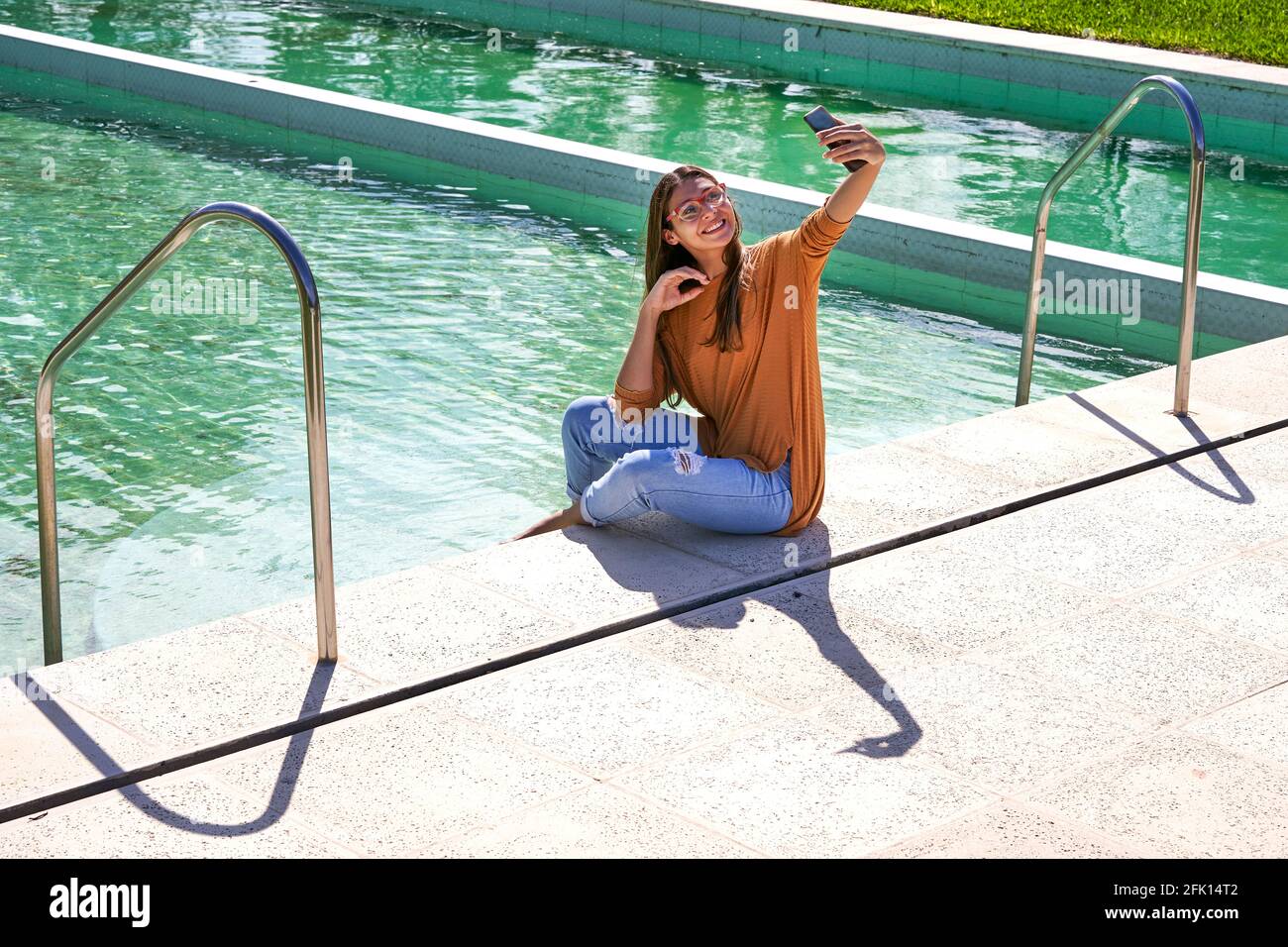 Junge Frau Brünette nimmt Selfie auf Schwimmbad Stockfoto