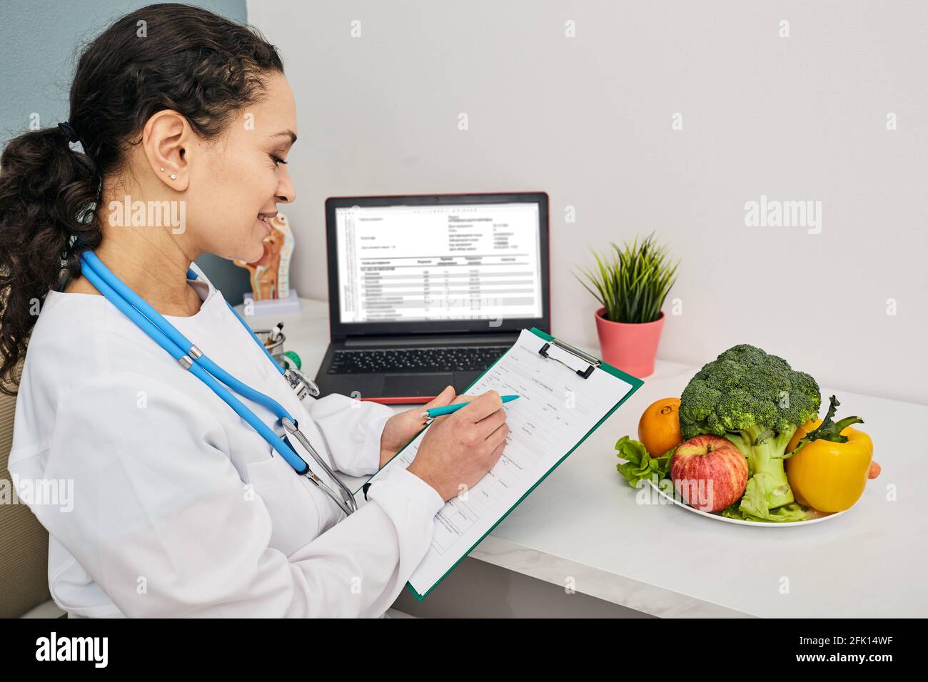 Ernährungsberaterin erstellt einen personalisierten Speiseplan für ihre Patientin. Gemüse und Obst für eine gesunde Ernährung Stockfoto